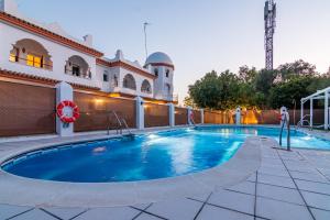 a swimming pool in front of a building at Hostal Alhambra in Zahora