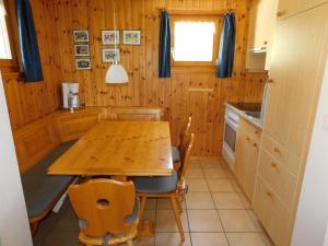 cocina con mesa de madera y sillas en Ferienwohnung Traumzeit EG, en Bellwald