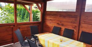 a dining room with a table and chairs and two windows at Privat DAŇO in Lisková