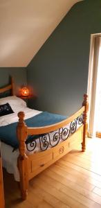 a bedroom with a wooden bed with a wooden floor at The Cosy Loft in Cong