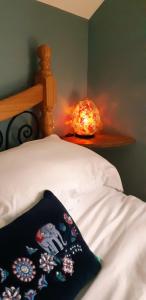 a close up of a bed with a blanket and a lamp at The Cosy Loft in Cong