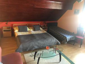 sypialnia z 2 łóżkami i szklanym stołem w obiekcie Anita Apartmanház w mieście Orfű