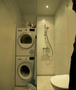 ein Badezimmer mit einer Waschmaschine und einer Waschmaschine in der Unterkunft Cozy and silent ground floor apartment in Kopenhagen