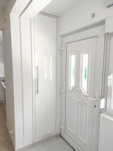 una porta bianca in una stanza bianca con finestra di Dulcis a Spalato (Split)