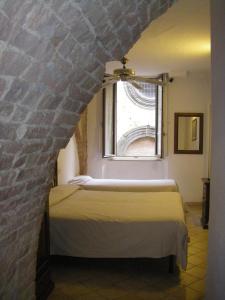 una camera con due letti e una finestra di Albergo Cannon d'Oro a Siena