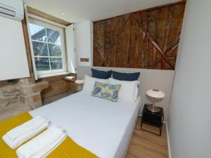 ein Schlafzimmer mit einem großen weißen Bett und einem Fenster in der Unterkunft Ponte D Luis I Apartments in Porto