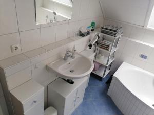 ein weißes Badezimmer mit einem Waschbecken und einem Spiegel in der Unterkunft 1-Zimmer-Wohnung Nähe Playmobil Funpark in Oberasbach