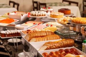un buffet lleno de diferentes tipos de repostería en Alven Hotel by Slaviero Hotéis en Joinville