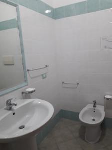 een badkamer met een wastafel en een toilet bij Villa dei pini in Vieste