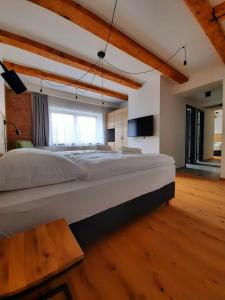 - duże białe łóżko w pokoju z drewnianą podłogą w obiekcie Apartmány Resort Na Horské w mieście Malá Morávka