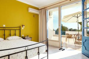 ein Schlafzimmer mit einem Bett und eine Terrasse mit einem Sonnenschirm in der Unterkunft Sea Melody in Lefkos Karpathos