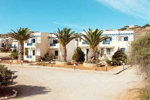 a large white building with palm trees in front of it at Sea Melody in Lefkos Karpathou