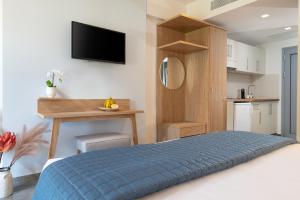 a bedroom with a bed and a desk with a tv at Notia Luxury Living in Porto Koufo