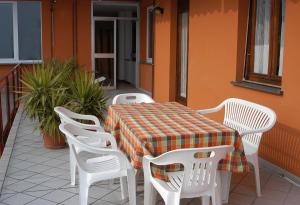 uma mesa e cadeiras numa varanda com uma mesa e uma toalha de mesa em Casa Miralago em Menaggio