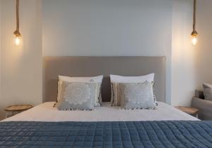 a bedroom with a blue bed with two pillows at Notia Luxury Living in Porto Koufo