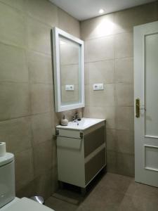 y baño con lavabo, espejo y aseo. en Apartamento adosado cerca del mar, en Gran Alacant