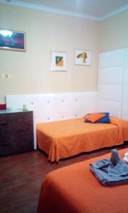 a bedroom with two beds with orange sheets at Villa Morgante B&B in Pedara
