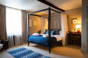 a bedroom with a canopy bed and a blue rug at Royal Oak Ramsden in Ramsden