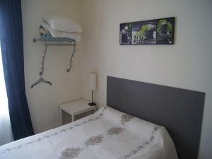 a bedroom with a bed and a lamp and a picture on the wall at Hôtel Moderne in Maisons-Alfort