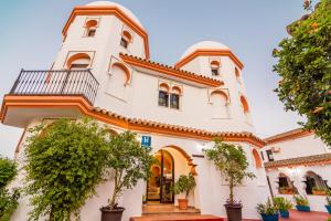 a large white building with a tower at Hostal Alhambra in Zahora