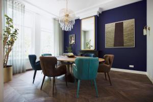 een eetkamer met blauwe muren en een houten tafel en stoelen bij MUZE Hotel Utrecht in Utrecht