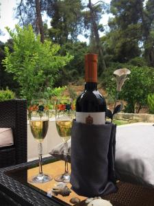 a bottle of wine sitting on a table with wine glasses at Villa Opali in Kassandra