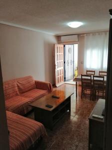 uma sala de estar com um sofá e uma mesa em Apartamento adosado cerca del mar em Gran Alacant