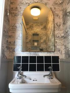 a bathroom with a sink and a mirror at Netherdene Country House Bed & Breakfast in Troutbeck