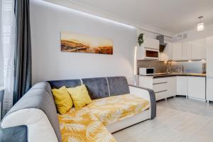 een woonkamer met een bank en een keuken bij Apartamenty Silver 6 in Szczecin