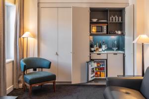 a living room with a chair and a refrigerator at The Resident Soho in London