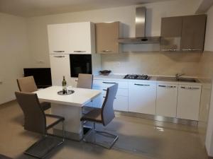 a kitchen with a white table and chairs in it at Guesthouse Vesna in Senj
