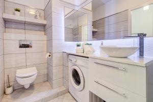 een badkamer met een wasmachine en een wastafel bij Apartamenty Silver 6 in Szczecin