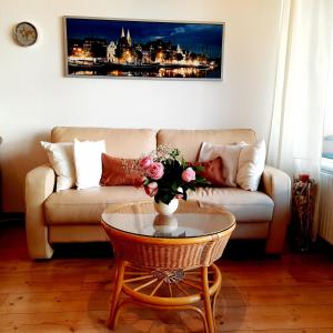 a living room with a couch and a table with a vase of flowers at Apartment 3 Minuten zu Fuss zum Meer (40m²) in Lübeck