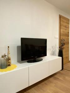 een wit entertainmentcentrum met een flatscreen-tv bij Apartma LUPIS in Podvolovljek