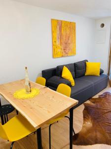 a living room with a blue couch and a wooden table at Apartma LUPIS in Podvolovljek +23 photos