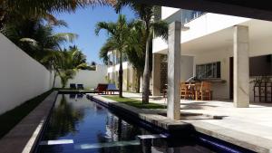 an external view of a house with a swimming pool at KiteBar Hotel in Cumbuco