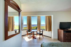 a room with a table and chairs and a television at Epworth By The Sea in Saint Simons Island