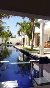 einen Pool mit Palmen vor einem Haus in der Unterkunft KiteBar Hotel in Cumbuco
