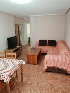 um quarto com uma cama, uma mesa e uma televisão em Apartamento adosado cerca del mar em Gran Alacant
