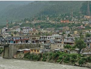 a group of buildings on a hill next to a river at 5 Elements Hotels in Uttarkāshi