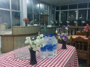 a table with vases of flowers and bottles of water at 5 Elements Hotels in Uttarkāshi