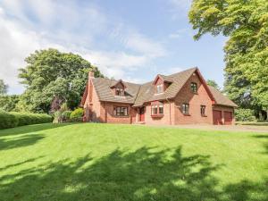 a large brick house with a green lawn at Auburn Cottage in Arbroath