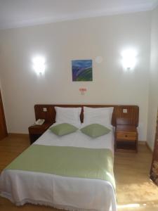 En eller flere senge i et værelse på Hotel Bonjardim
