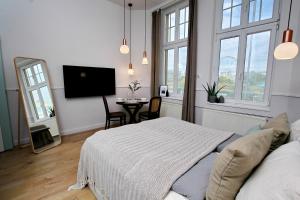 - une chambre avec un lit et une table avec une télévision dans l'établissement Gellerico Apartments Deák Square, à Budapest