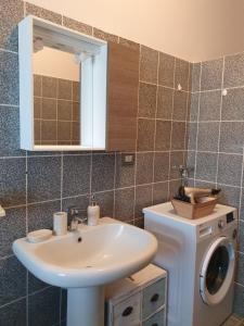 a bathroom with a sink and a washing machine at Giolitti Luxury Apartment in Cuneo