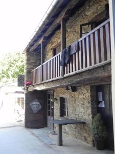 un edificio con un banco delante de él en Albergue Atrio, en Triacastela