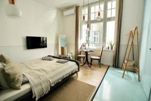 a bedroom with a bed and a table and window at Classy Apartments Deák Square in Budapest