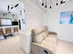 a living room with a couch and a dining room at SANDY BAY Villa in Ayia Napa