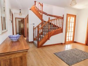 a living room with a wooden staircase and a rug at Auburn Cottage in Arbroath