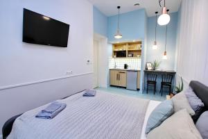 1 dormitorio con 1 cama y TV en la pared en Gellerico Apartments Deák Square en Budapest